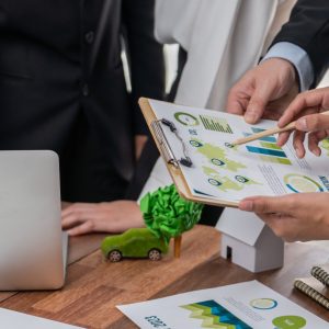 Eco business company meeting with group of business people using laptop to plan strategy and discuss marketing of eco-friendly and clean energy products. Green business company concept. Trailblazing